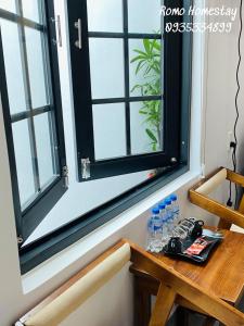 a window with water bottles on a wooden table at Romo Homestay in Quảng Ngãi