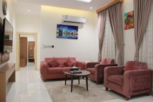 a living room with two red couches and a table at Five Season Hotel in Al Khobar
