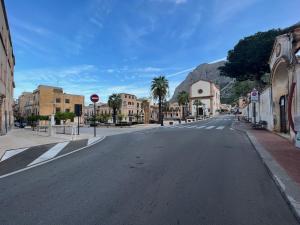 uma rua vazia numa cidade com uma montanha em b&b antichi colori em Cinisi