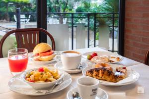 a table with plates of breakfast foods and drinks at Hotel Venezia in Marina di Pietrasanta