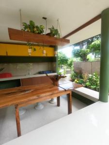 eine Küche mit einem Holztisch und einigen Pflanzen in der Unterkunft Marelocca Beach House in Calatagan