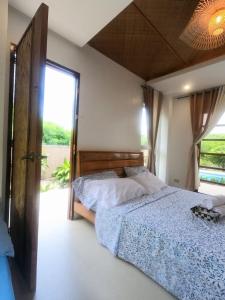1 Schlafzimmer mit 2 Betten und einem großen Fenster in der Unterkunft Marelocca Beach House in Calatagan