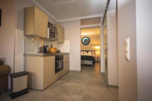 a room with a kitchen and a hallway with a bed at 1880 Lofthaus & Apartmenthaus in Gera