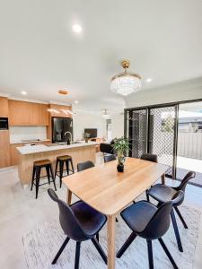 Il comprend une cuisine et une salle à manger avec une table et des chaises en bois. dans l'établissement New Home close to Airport hospital Coles & Resto, à Mackay