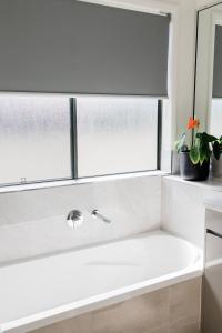 La salle de bains est pourvue d'une baignoire et d'une fenêtre. dans l'établissement New Home close to Airport hospital Coles & Resto, à Mackay
