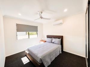 biała sypialnia z łóżkiem i oknem w obiekcie New Home close to Airport hospital Coles & Resto w mieście Mackay