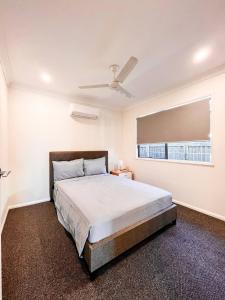 1 dormitorio con cama y ventana en New Home close to Airport hospital Coles & Resto, en Mackay