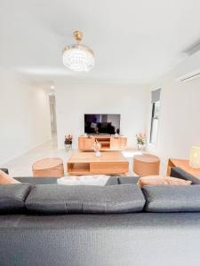 sala de estar con sofá y mesas en New Home close to Airport hospital Coles & Resto en Mackay