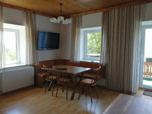 a dining room with a table and chairs and two windows at Ferienwohnung Göriacher Stern in Pusarnitz