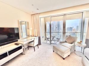 a living room with a large television and a couch at Fashion Avenue Dubai Mall Residences - Studio with balcony in Dubai