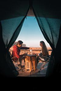 a man and woman sitting at a table in a tent at Nujoum Overnight Camp with Signature Desert Safari in Dubai