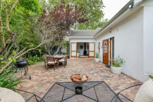 a patio with a table and a grill at Constantia Oasis Petite in Cape Town