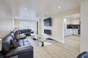 uma sala de estar com um sofá de couro e uma lareira em Host & Stay - Violet's View em Whitby