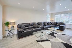 uma sala de estar com um sofá de couro e uma mesa de vidro em Host & Stay - Violet's View em Whitby