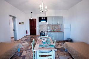 a kitchen with a table and chairs in a room at Apartment with sea view - Creta in Ferma +26 photos