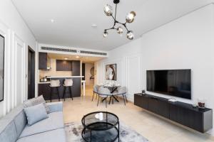 - un salon avec un canapé et une télévision dans l'établissement Nasma Luxury Stays - Elegant 1BR With Stunning View of Park Avenue, à Dubaï