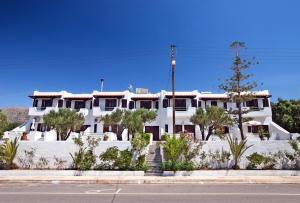 a white building with trees in front of a street at Apartment with garden view - Creta in Ferma
