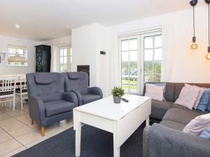 een woonkamer met een bank, stoelen en een tafel bij 8 person holiday home in Gjern in Gjern