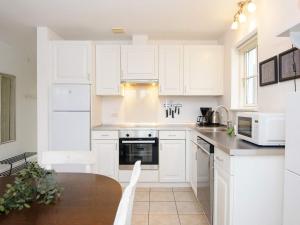 a white kitchen with white cabinets and a table at 8 person holiday home in Gjern in Gjern