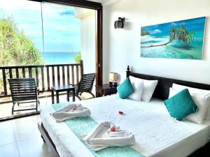 a bedroom with a bed with a view of the ocean at The Pleasure Kosgoda in Bentota