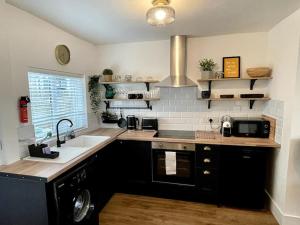 a kitchen with a sink and a counter top at Terrace House - Charming home near town and train station in Nantwich