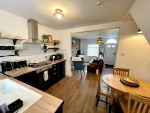 a kitchen and living room with a table and a dining room at Terrace House - Charming home near town and train station in Nantwich