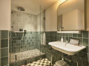 a bathroom with a sink and a shower at The Hoxton Lloyd Amsterdam City Centre East in Amsterdam +43 photos