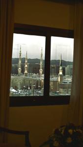 a view of a city from a bedroom window at One Inn Hotel in Al Madinah