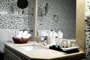 a bathroom with a sink and a mirror at One Inn Hotel in Al Madinah +57 photos