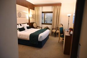 One Inn Hotel في المدينة المنورة: غرفة في الفندق مع سرير ومكتب