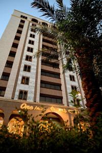 One Inn Hotel في المدينة المنورة: مبنى طويل عليه نخلة