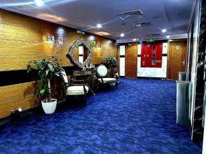 a waiting room with a mirror and a blue carpet at One Inn Hotel in Al Madinah