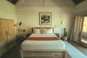 een slaapkamer met een groot bed in een kamer bij CARI Surf Camp & Studio's in Uluwatu +28 foto's