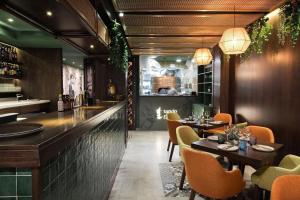 um restaurante com mesas e cadeiras e um bar em Studio 31 with kitchenette at the new Olo living em Paceville