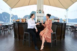 un hombre y una mujer sentados en un bar en Paradise Elegance Cruise Halong, en Ha Long