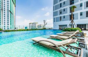 a swimming pool with chaise lounge chairs and a hotel at Saigon Authentic Apartments - Amazing Infinity Pool and FREE Daily Breakfast Voucher, Walking Tour and 4G SIM card for 3 nights booking in Ho Chi Minh City