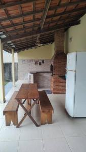 un tavolo da picnic e un frigorifero in una stanza di Casa Castelhanosbeach - 100 m do mar a Anchieta
