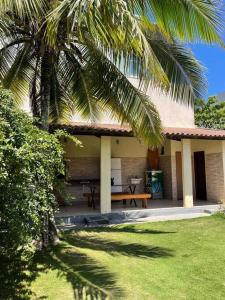 una casa con un tavolo da picnic e una palma di Casa Castelhanosbeach - 100 m do mar a Anchieta Altre 17 foto