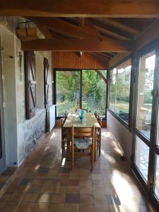 comedor con mesa y algunas ventanas en Villa Thérèse en Beaulieu-sur-Dordogne