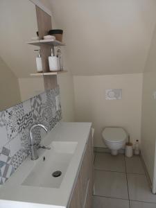 La salle de bains blanche est pourvue d'un lavabo et de toilettes. dans l'établissement Villa Thérèse, à Beaulieu-sur-Dordogne