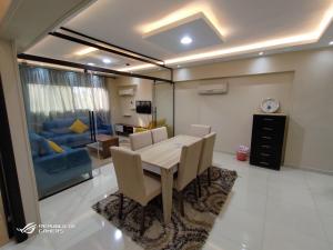 une salle à manger avec une table et un canapé bleu dans l'établissement 3 Bedrooms Luxurious Appartment in Nasr City, au Caire