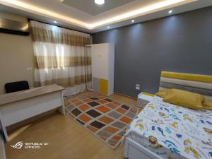 - une petite chambre avec un lit et un bureau dans l'établissement 3 Bedrooms Luxurious Appartment in Nasr City, au Caire