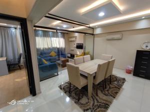 - une salle à manger et un salon avec une table et des chaises dans l'établissement 3 Bedrooms Luxurious Appartment in Nasr City, au Caire