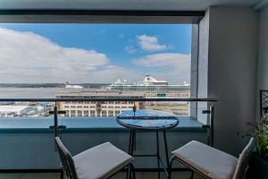 a balcony with a table and chairs and a cruise ship at Luxurious 1 Bed - RIVER VIEW in Liverpool