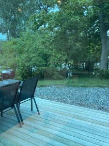 a patio with a table and chairs on a wooden deck at Minihus i Enskede-Årsta-Vantörs in Stockholm