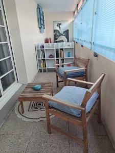 ein Wohnzimmer mit zwei Stühlen und einem Tisch in der Unterkunft Appartement cosy avec jardin et parking in Gennevilliers