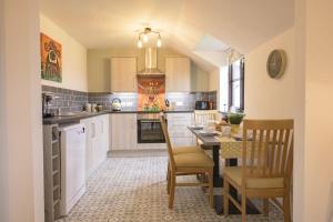 a kitchen with a table and chairs and a dining room at Oak Lodge House in Leyburn