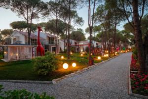 eine Straße mit einem Haus mit einer Giraffenstatue und Lichtern in der Unterkunft Selectum Luxury Resort Belek in Belek