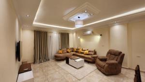 een woonkamer met een bank en 2 stoelen bij Wa set Luxor Apartment in Luxor