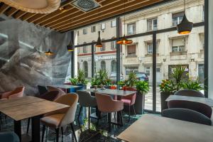 a restaurant with tables and chairs and windows at Onyx Luxury Budapest in Budapest